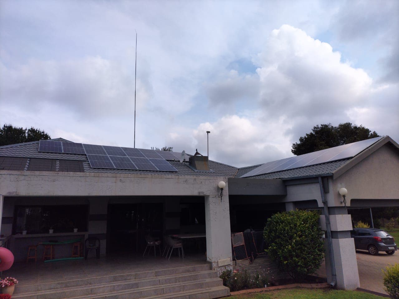 Solar panels on the tiled roofs of a South African home under a cloudy sky